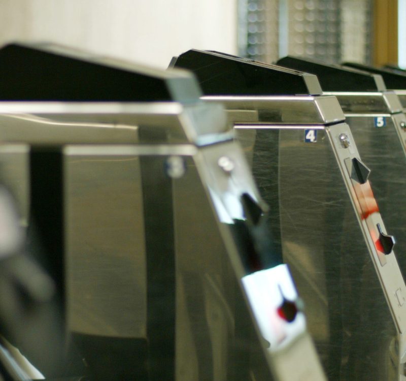 Metal turniquets in the underground. Woman entering the a underground station.